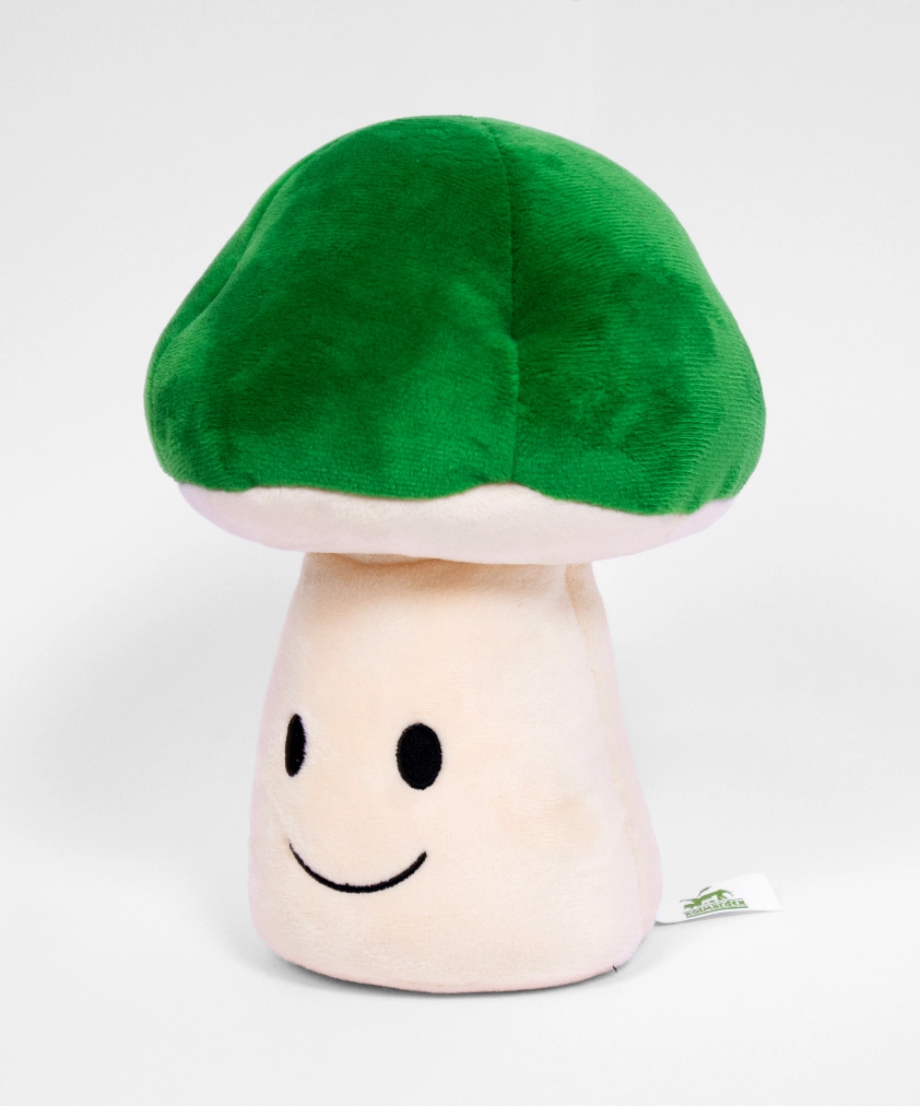 En mjuk plyschleksak formad som en grön svamp med en gräddfärgad fot, som har ett enkelt broderat glatt ansikte.